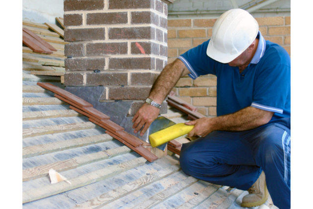 Roof repair worker with white hard hat on